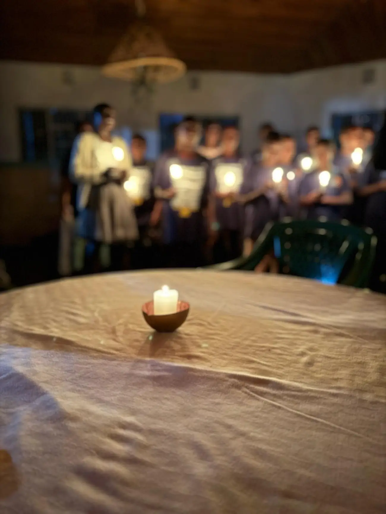 Community members holding candles during a reflective gathering supported by Kenya Relief