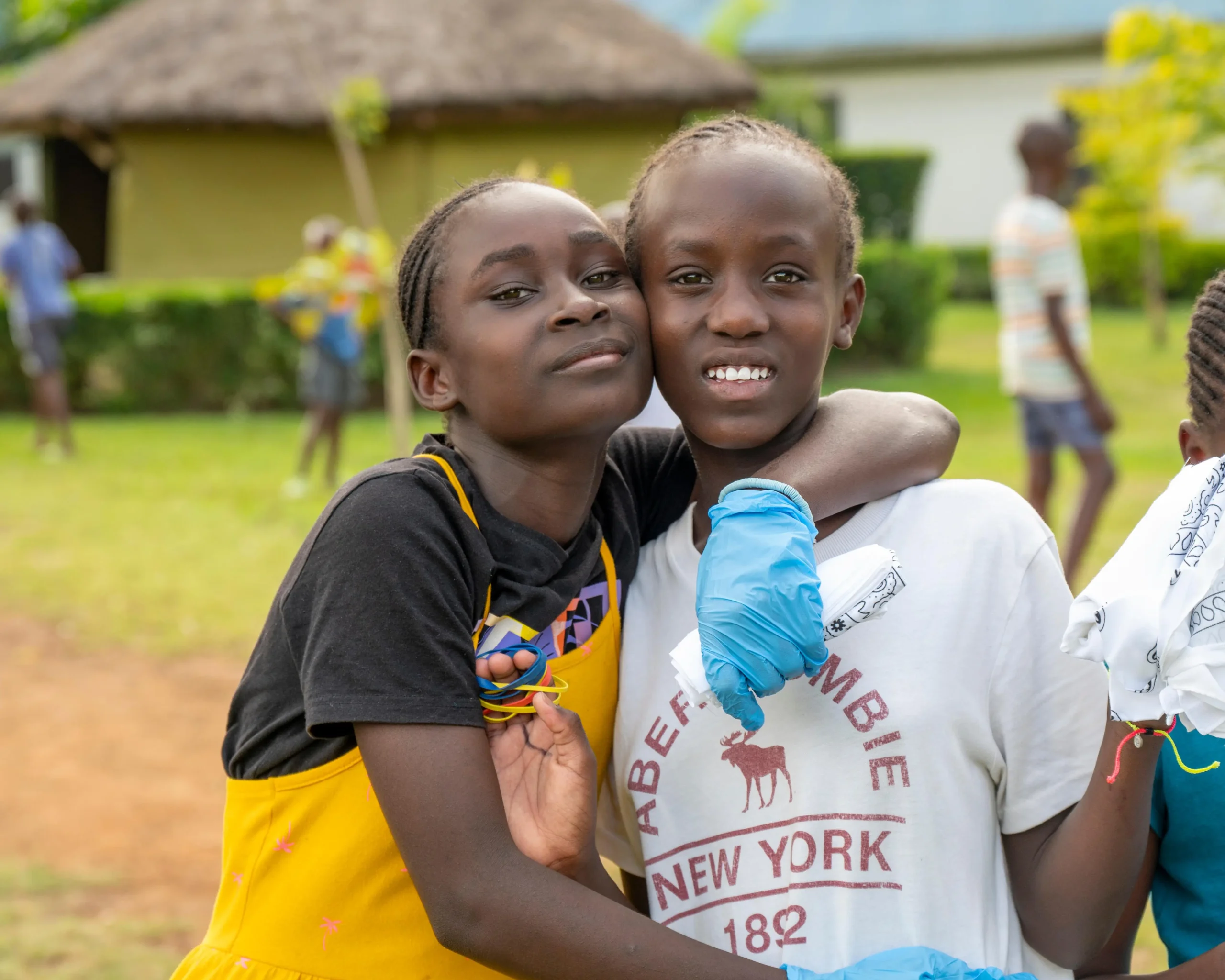 Two girls hugging and smiling during a Kenya Relief community activity