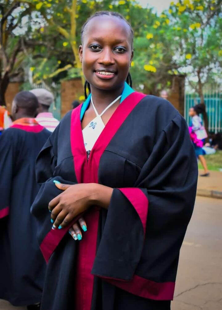 Rehema, a Kenya Relief graduate, wearing her graduation gown after completing her studies at Kenya Medical Training College