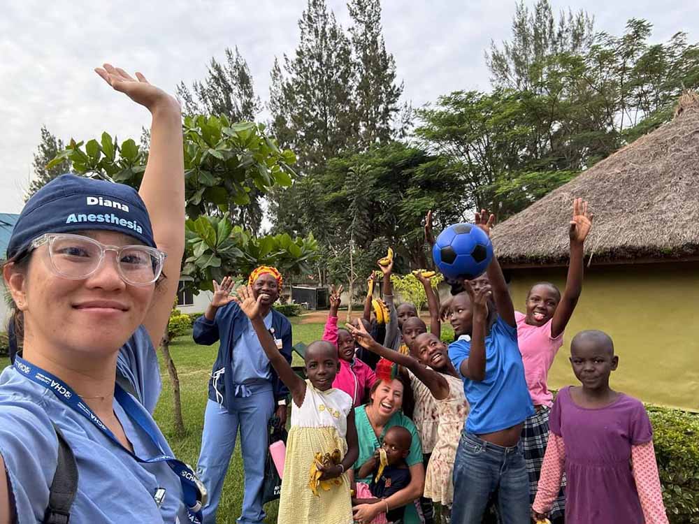 Happy Kenyan children smiling with a female healthcare volunteer who serves with purpose in a community-mission promoting education and hope.